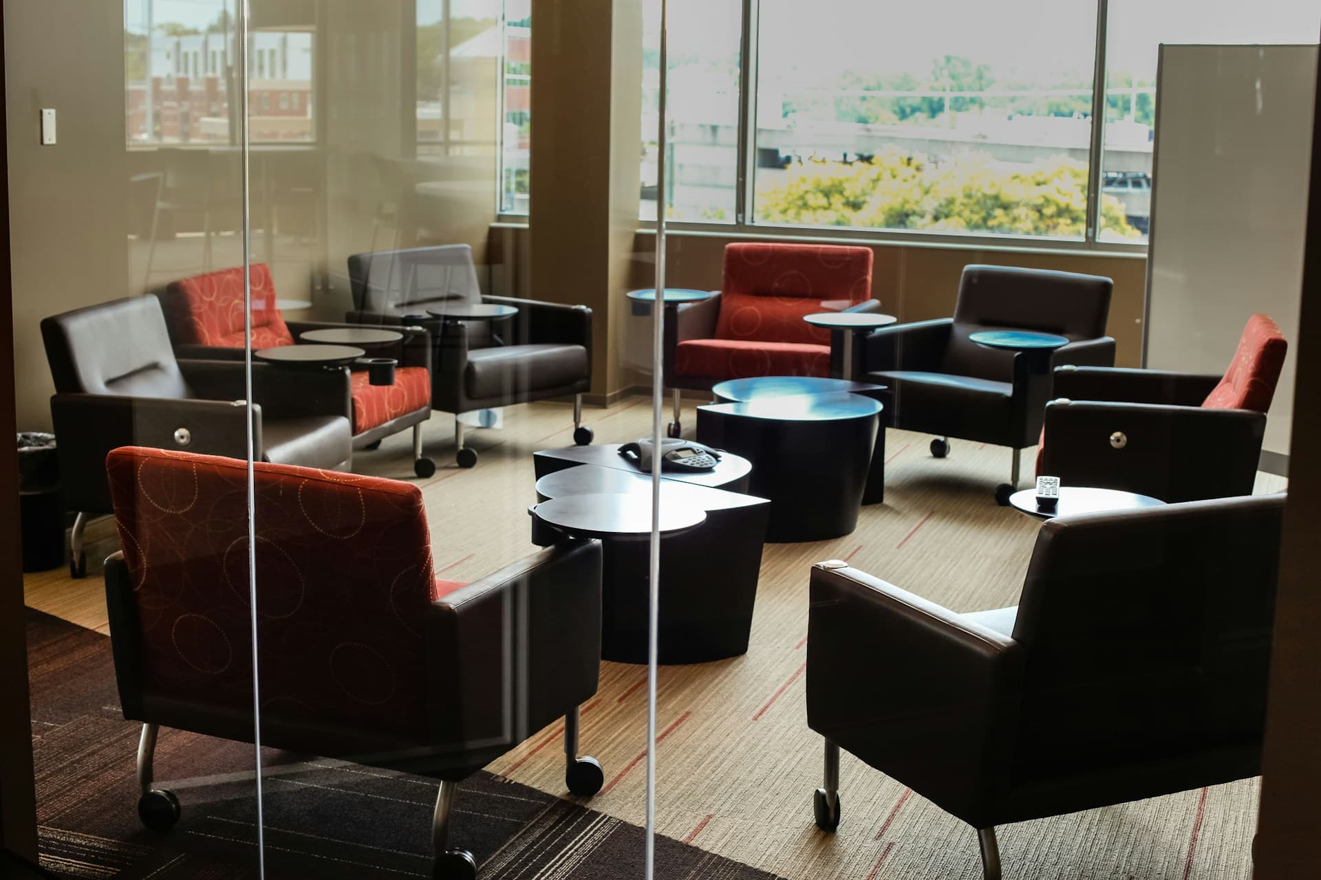 An empty corporate conference room with a long table and city light through tall windows.